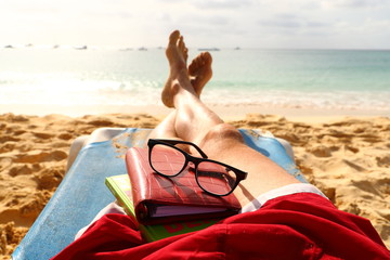 mens legs and feet resting on a beach chair portraying relaxation on holiday