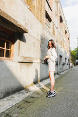 Portrait of beautiful young asian woman posing near building