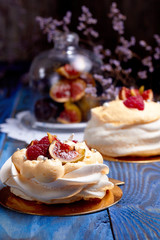 Two dessert Pavlova with raspberries on old blue wooden table. Meringues on a rustic background