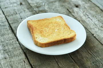 Fototapeta na wymiar Toasted toast on a plate on a dark wooden background. English breakfast.