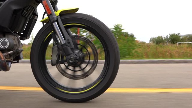 Rolling shot of a motorcycle front wheel on the road.