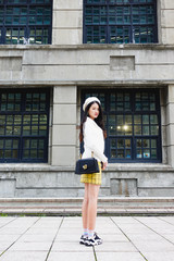 Portrait of beautiful young asian woman posing near building