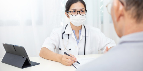 Portrait of asian woman doctor wear protection face mask showing patient some information on digital tablet clip board, epidemic flu Coronavirus. Medical preventive banner
