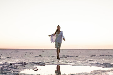 portrait of a girl against the background of an interesting and beautiful landscape of a salt lake
