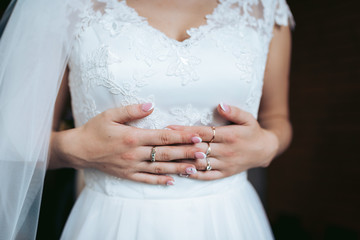 bride in white wedding dress with rings