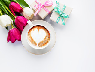 Coffee cup with latte art and tulips