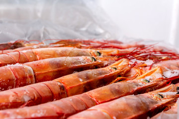 Frozen large raw uncooked shrimps on counter.