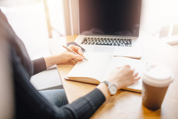 Close-up female hand making notes and notebook, businesswoman woman online training and work while sitting home coronavirus pandemic