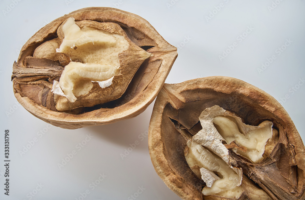 Wall mural Two half walnuts on a light background