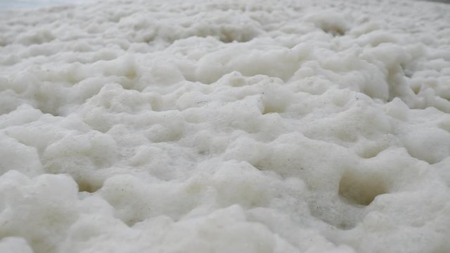 Abstract closeup of a lot of sea foam in a storm on the seashore.