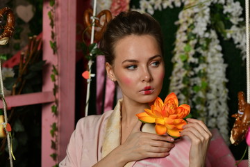 girl in japanese kimono posing on the background of flowering plants