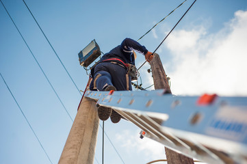 An electrician fixing the electrical cables for the street light.