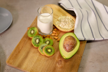 Fresh smoothie made of kiwi, avocado, oatmeal and skim milk near a burlap towel. Decorated on top. Morning meal in the village with fresh ingredients.