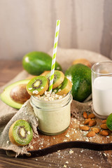 Fresh smoothie made of kiwi, avocado, oatmeal and skim milk near a burlap towel. Decorated on top. Morning meal in the village with fresh ingredients.