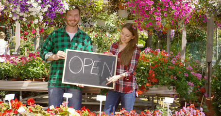 Two florists with open sign in their shop