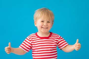 Happy child wearing striped shirt against blue background