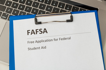 Fafsa. Student aid statement form and money on the tablet