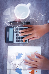 Person computing on calculator with financial analysis graphs. Woman working with diagram....
