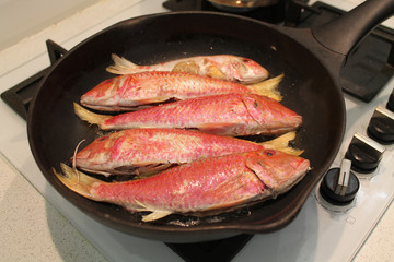 Fish is fried in a frying pan. The concept of cooking healthy food