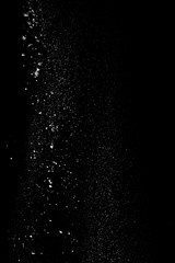 White dust similar to flour and snow is actively scattered isolated on black background