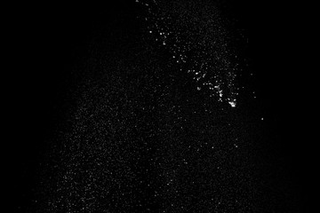 White sugar with flour thrown isolated on black background