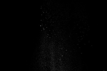 White dust similar to flour and snow is actively scattered isolated on black background