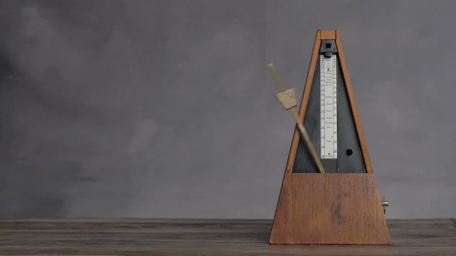 Vintage metronome shot keeping tempo in a seamless loop.