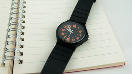 The black wristwatch is put on the pocket watch. - obrazy, fototapety, plakaty