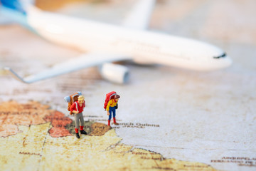 Fototapeta na wymiar Miniature people: Group backpacker on vintage world map with airplane using as business trip traveler adviser agency or explorer on earth background concept.