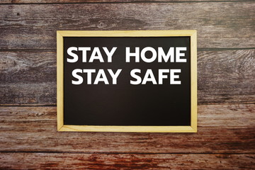 Stay Home Stay Safe word letter written on blackboard Top view on wooden background