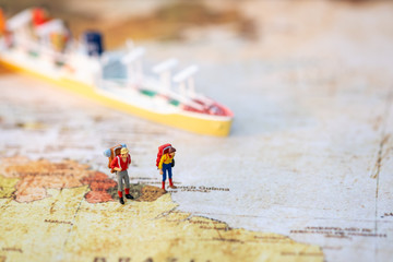 Miniature people: Group backpacker on vintage world map with boat using as business trip traveler adviser agency or explorer on earth background concept.