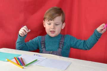 little boy drawing with color pencils