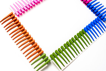 Frame of multi- colored hair clips on a white background, space for inscriptions, copy of the space