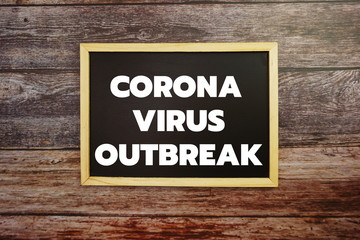 Corona Virrus Outbreak word letter written on blackboard Top view on wooden background