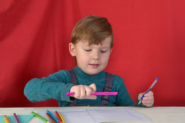 little boy drawing with color pencils