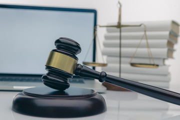 Workspace of lawyer with laptop blank white screen and law wooden gavel,legal book and brass scale...