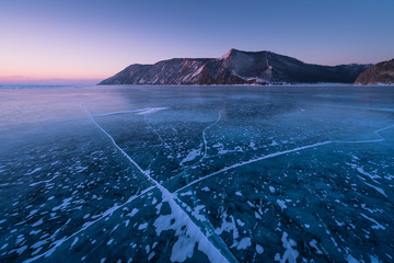 Forzen lake Baikal in winter season at sunrise view from Uzury bay, crack on smooth surface of ice,...