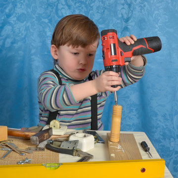 Little boy playing with dad's tools