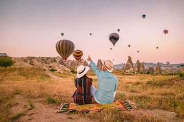 Cappadocia Turkey during sunrise, couple mid age men and woman on vacation in the hills of Goreme...
