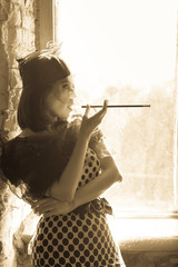 Retro image of beautiful woman near window with mouthpiece