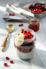 Fresh pomegranate berries, banana and sunflower seeds in chocolate granola to chia pudding with yogurt.