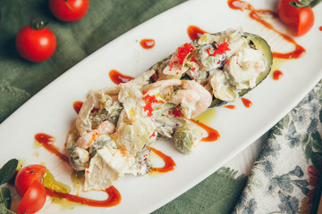 Roasted vegetables on the grill. A hot dish made of vegetables with sauce. Tomatoes, cabbage and zucchini on a plate.
