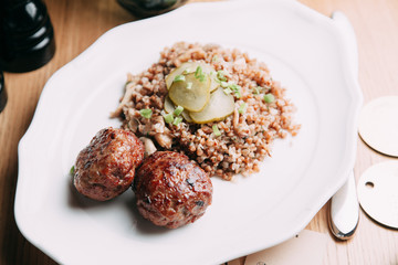 Meat cutlets with garnish on a plate. Cutlets with buckwheat and sauce.