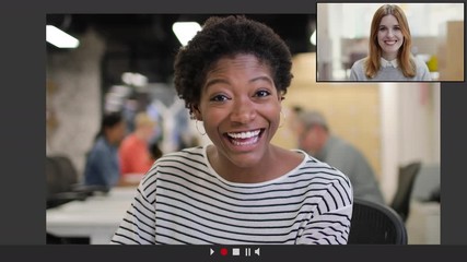 Two adult women in office using Video Conference for video call with colleagues