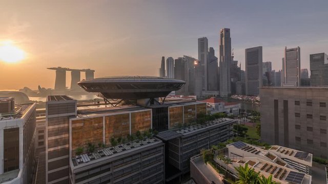 Sunrise over Colorful of Singapore Central business district aerial timelapse hyperlapse cityscape skyline at Marina Bay with Singapore Academy of Law and Parliament House from above.
