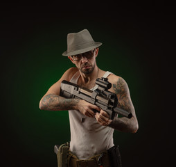 Fototapeta premium an athletic guy with a tattoo poses with a shotgun