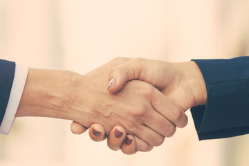 Closeup of female handshake. Business women in office jackets shaking hands. Businesswomen concept