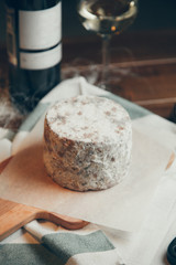 Composition with wine and Flatley cheese. Cheese with a blue noble mold on a wooden Board.