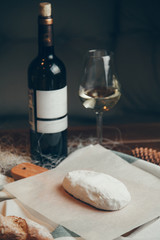  Farm cheese with a bottle of wine. Homemade cottage cheese on a wooden Board.