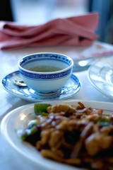 Steamed meat with vegetables and cup of tea in a Chinese restaurant. Selective focus.